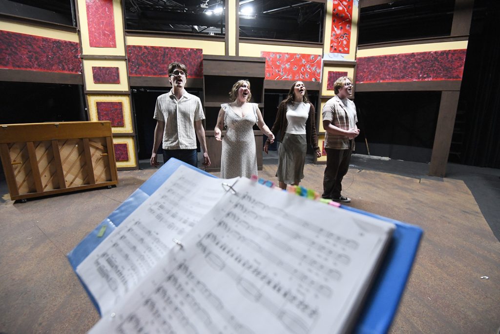 Students lined up and singing on the set of Thous Hast Thy Will in preparation for the upcoming performances. 