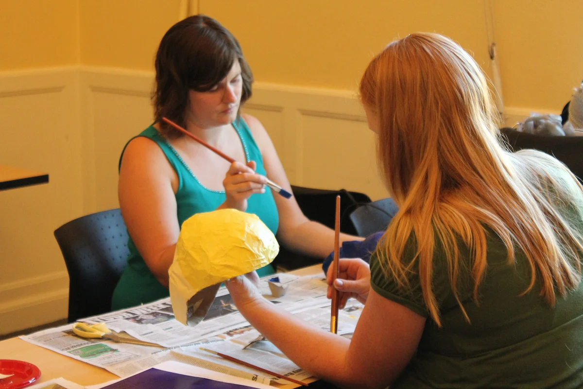 Elementary Education students paint masks during a lesson