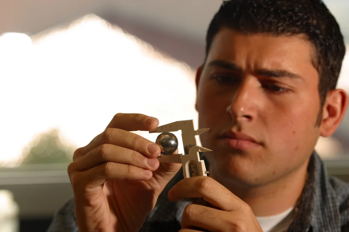 EOU Student uses calipers check tolerances on a ball bearing