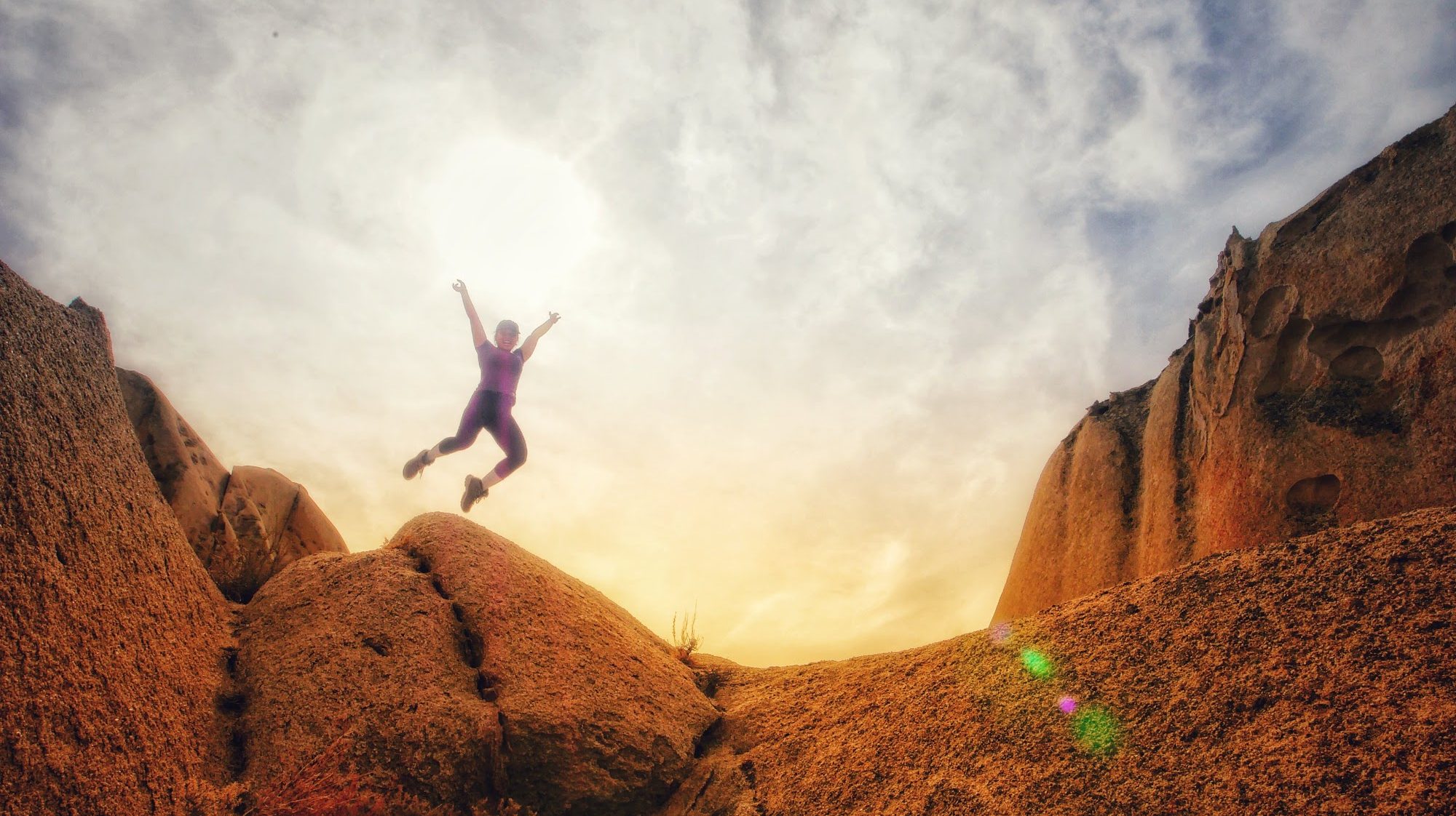 A student jumping off of a rock while on an Oudoor Adventure Program trip