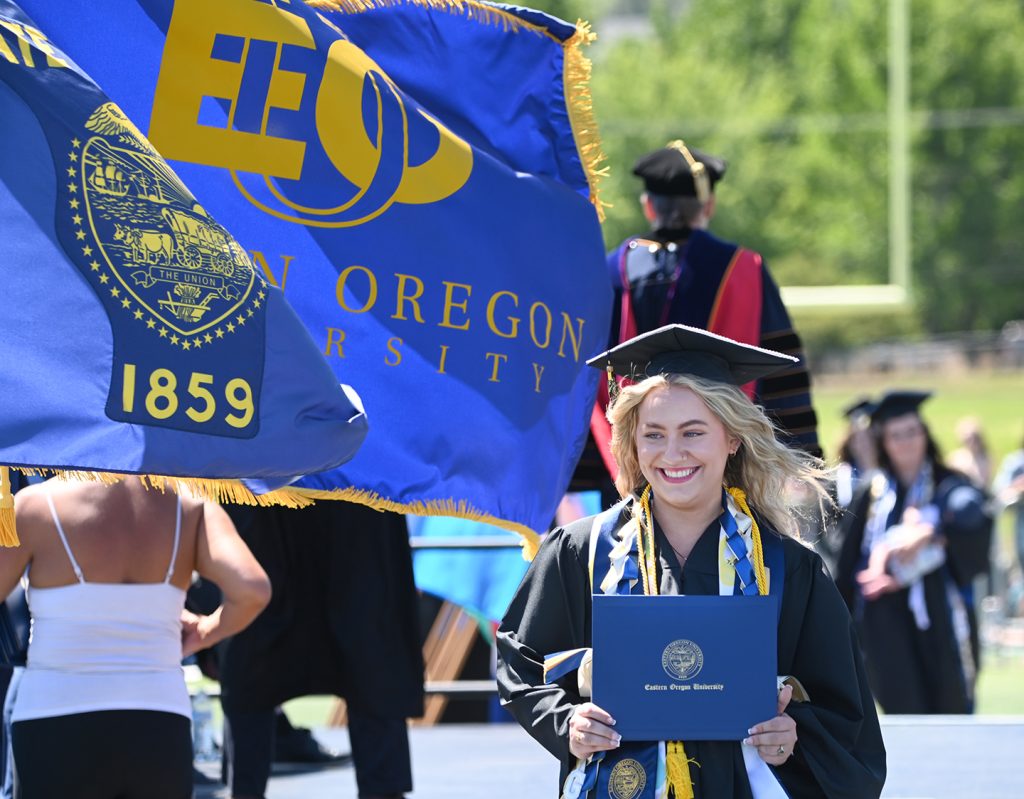 Students celebrating at commencement, highlighting record EOU student success and rising graduation rates.