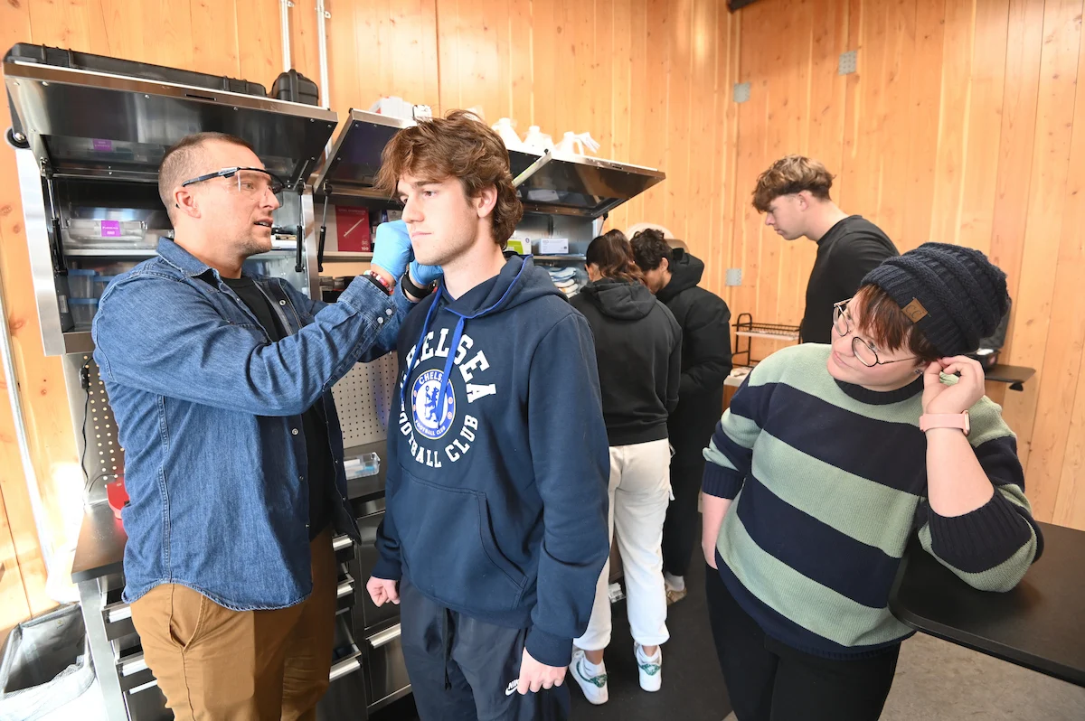 Dr. Kyle Pfaffenbach helps to prepare a student for lab testing in the Health and Human Performance lab