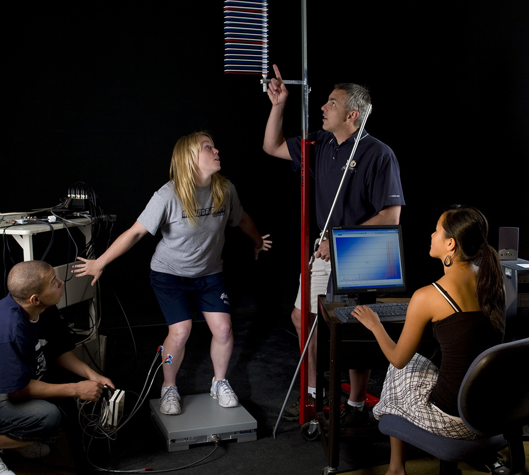 Professor Darren Dutto works with students in the Health and Human Performance Lab