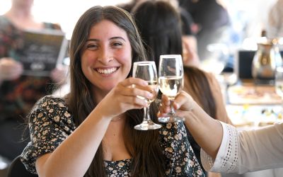 A woman smiling and toasting at the scholarship celebration
