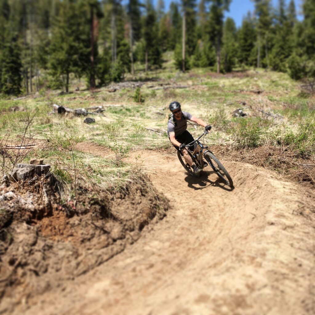 Mountain biker at MERA rounding a banked turn. 