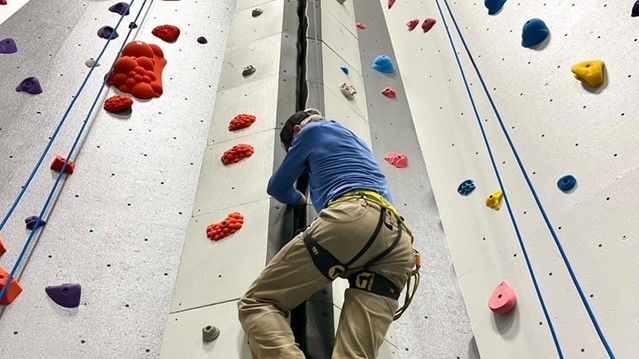 Student climbing on the main wall in the EOU Climbing Center