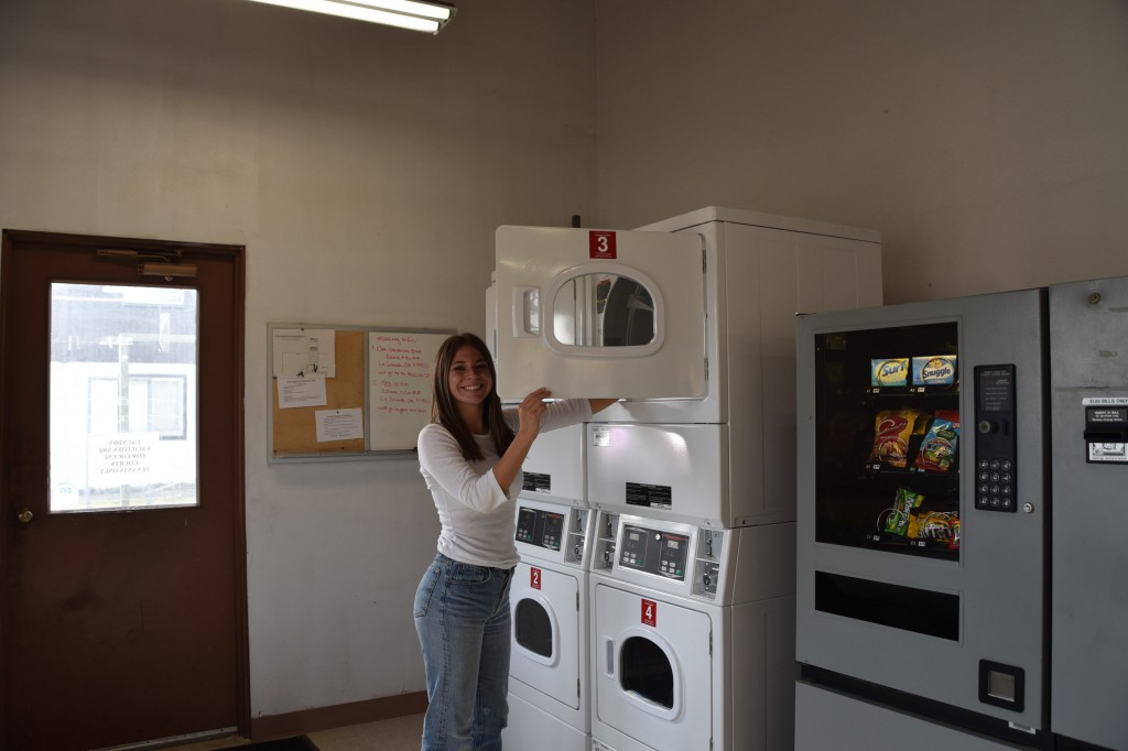 The Eocene laundry room with a student showing off the washing machines