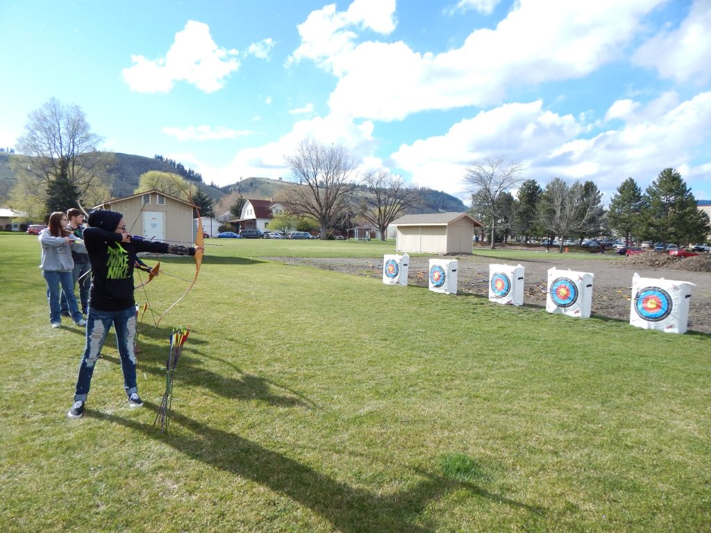 EOU students aim their bows at targets on the EOU campus while taking the OUT 180 Beginning Archery course. 