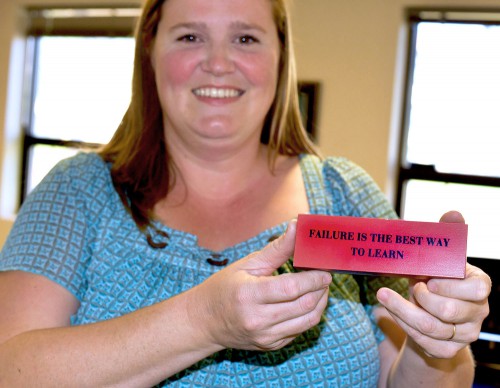 Jacobson holds up a plaque featuring her favorite motto displayed in her office in Loso Hall. It reads "failure is the best way to learn."