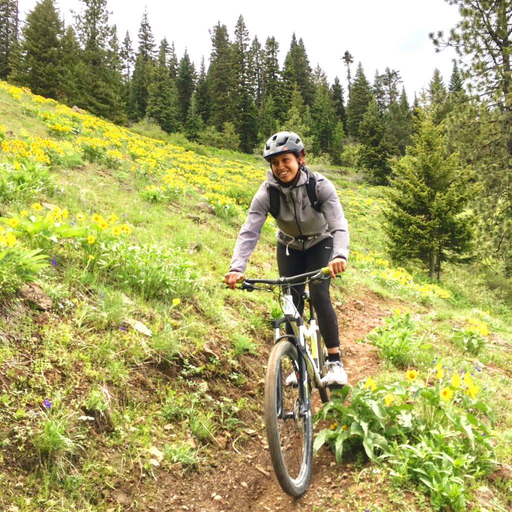 Mountain biker at MERA biking through a field of Balsam Root.