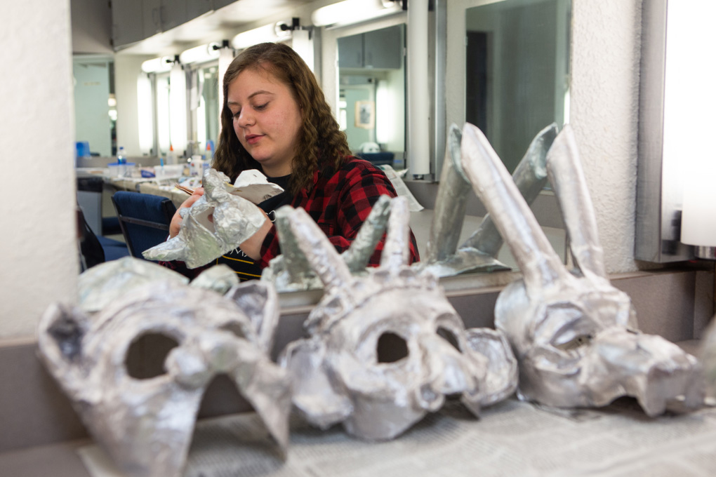 Student working on creating paper mâché masks for theater productions