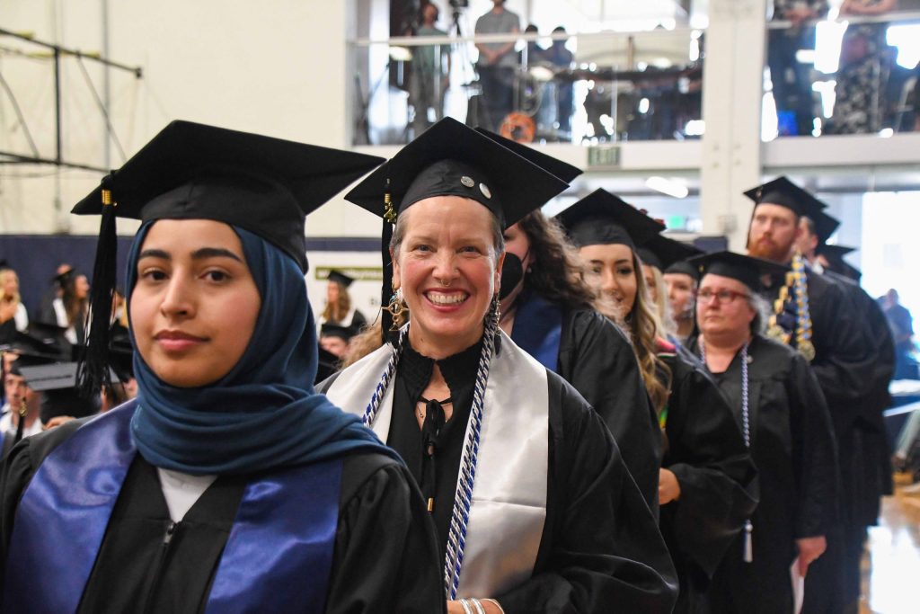 Master's Degree graduates walking to receive their diplomas at EOU Commencement