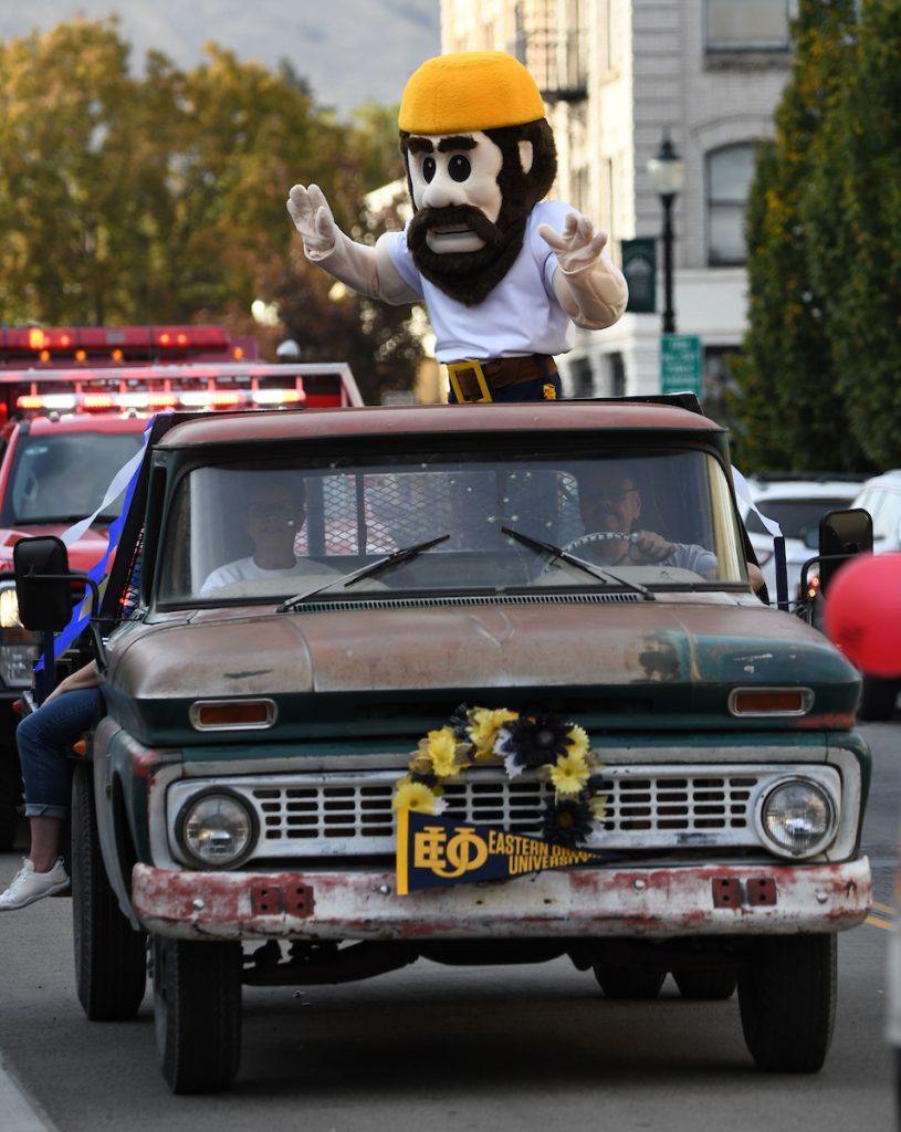 Monty the Mountaineer riding in the back of a truck at a parade