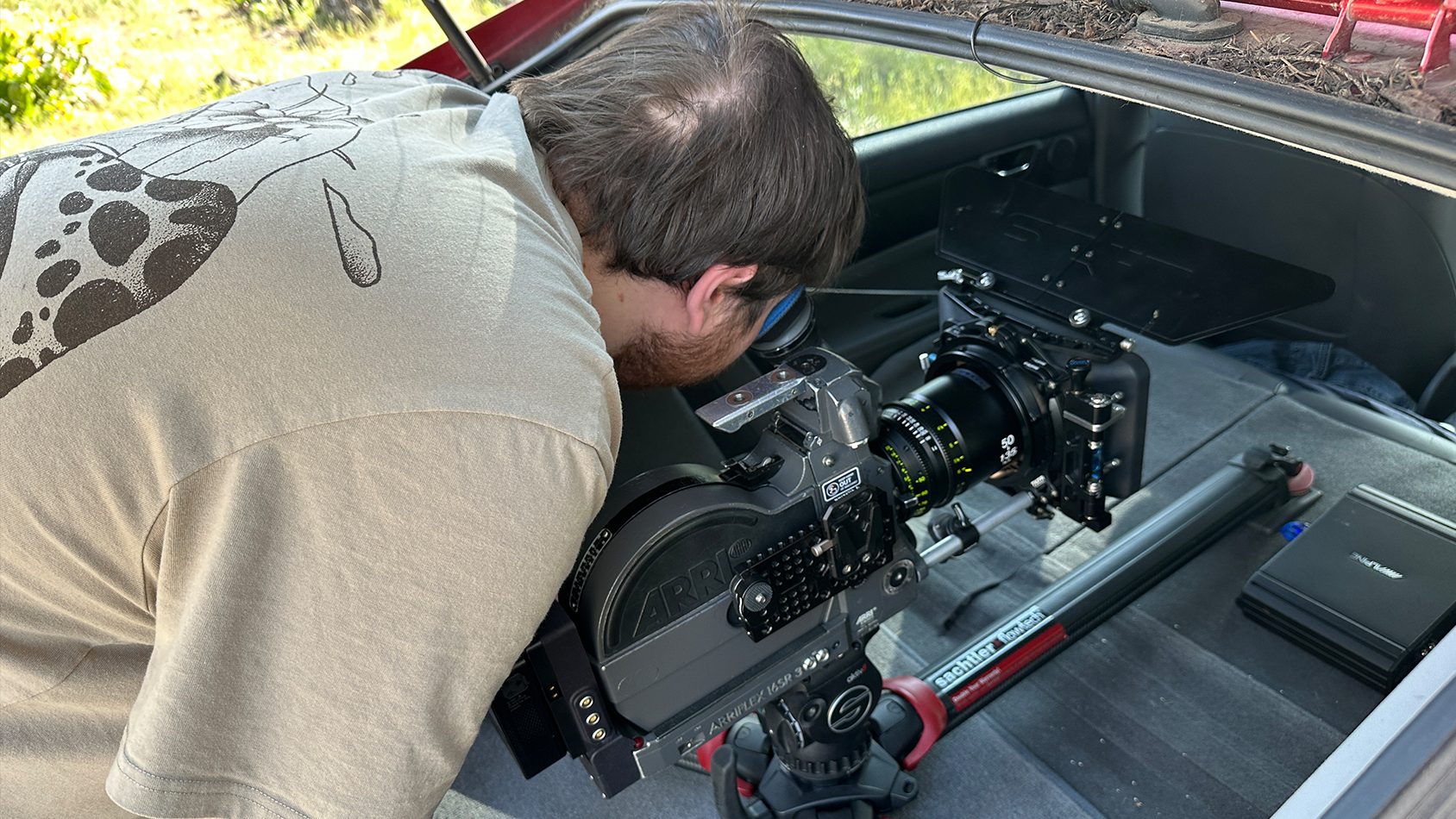 A student sets up a dolly shot in the back of a vehicle