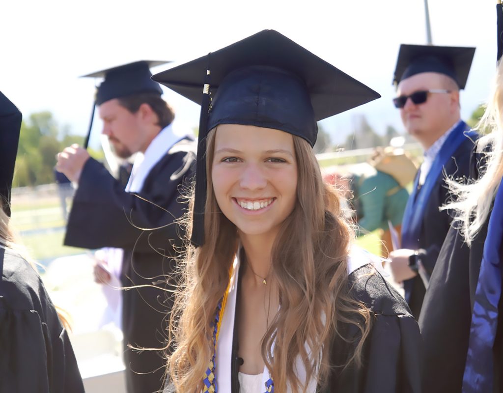 In this photo Megan Gustafson gives the camera one more smile before taking her seat at the 2025 Commencement Ceremony.  (EOU photograph / Maddie Barker)